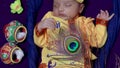 newborn baby boy in krishna dressed with props from unique perspective in different expression