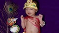 newborn baby boy in krishna dressed with props from unique perspective in different expression