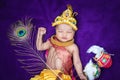 newborn baby boy in krishna dressed with props from unique perspective in different expression