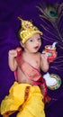 newborn baby boy in krishna dressed with props from unique perspective in different expression