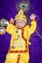 newborn baby boy in krishna dressed with props from unique perspective in different expression