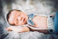 A newborn baby boy sleeping in knitted bow tie and trousers Royalty Free Stock Photo