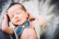 A newborn baby boy sleeping in knitted bow tie and trousers Royalty Free Stock Photo