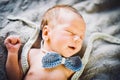 A newborn baby boy sleeping in knitted bow tie and trousers Royalty Free Stock Photo