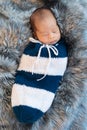 Newborn baby boy sleeping and swaddled in a knit wrap on bed Royalty Free Stock Photo