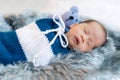 Newborn baby boy sleeping and swaddled in a knit wrap on bed Royalty Free Stock Photo