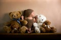 Newborn baby boy wearing a brown knitted bear hat and pants, sleeping on a shelf Royalty Free Stock Photo