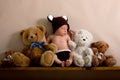 Newborn baby boy wearing a brown knitted bear hat and pants, sleeping on a shelf Royalty Free Stock Photo