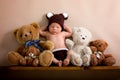 Newborn baby boy wearing a brown knitted bear hat and pants, sleeping on a shelf Royalty Free Stock Photo