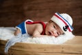 newborn baby boy wearing a white and blue sailor hat Royalty Free Stock Photo