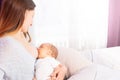 Newborn baby breastfeeding with mother sit on bed Royalty Free Stock Photo