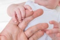 Newborn baby care concept. Man holds hand of a baby Royalty Free Stock Photo