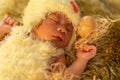 Newborn baby in chicken costume sleeping on fur bed Royalty Free Stock Photo