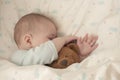 Newborn baby child asleep hugging a bear. Sleeping baby girl boy hid his nose in a teddy bear. Close-up soft focus Royalty Free Stock Photo