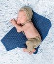 Newborn baby in costume lying on blue blanket