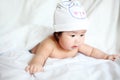 Newborn Baby with Cow Hat Lying Down on a White Blanket