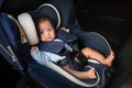 newborn baby crying while sitting in infant car seat, safety chair travelling