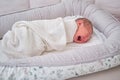 A newborn baby is crying swaddled on the bed. Child is a boy in a cocoon on a cot Royalty Free Stock Photo