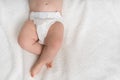 Newborn baby in diaper lying on white blanket