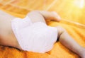 Newborn baby with Diapers - child wear white diaper and playing on a orange knitted blanket in the nursery