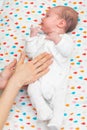 Newborn baby dressed in white laying on her back