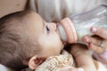 Newborn baby drinking milk from a bottle with the help of her mother Royalty Free Stock Photo