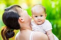 Newborn baby feeling happy and smiles with her mother in the garden. Portrait of Asian family.