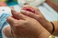 Newborn baby feet cupped into grandmothers hands