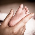 Newborn baby feet on female hand Royalty Free Stock Photo