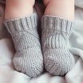 Newborn baby feet in grey knitted socks close-up. AI generated picture