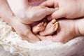 Newborn baby feet in mother and father hands. Parents holding legs of the kid in hands. Close up image.  Beautiful conceptual Royalty Free Stock Photo