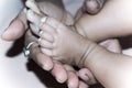 Newborn Baby Feet in Mother Hands. Beautiful infant little baby fingers and foot in mother`s palm. Close-up. Child health care an Royalty Free Stock Photo