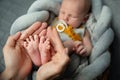 Newborn Baby Feet in Mother Hands. Mom holding sleeping Baby Legs in Arms. New Born Child Foot close up. Parent Love and Health Royalty Free Stock Photo