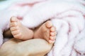 Newborn baby feet on the mother`s hand on a white blanket Royalty Free Stock Photo