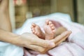 Newborn baby feet on the mother`s hand on a white blanket Royalty Free Stock Photo