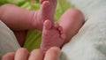 Newborn baby feet. Mother tickles baby heels.