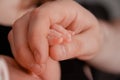 Newborn baby fingers in hands of mommy. Pregnancy, maternity, preparation and expectation motherhood, giving birth concept Royalty Free Stock Photo