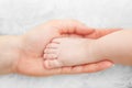 Newborn baby foot in mother's hand. Child care, love, protection Royalty Free Stock Photo