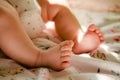Newborn baby girl in the cradle. Toddlers legs in the bed. Small baby`s feets and fingers Royalty Free Stock Photo