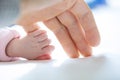 Newborn baby girl holding mother`s little finger