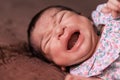 Newborn baby girl lying down and crying with cramps Royalty Free Stock Photo