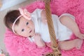 Newborn baby girl in pink blanket lying in basket looking at camera with interest. Top view Royalty Free Stock Photo