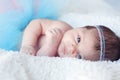 Newborn baby girl. Portrait of a newborn girl with a fluffy skirt and the pink - blue Headbands with beads. Baby is looking s Royalty Free Stock Photo