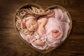 Newborn baby girl sleeping in a pink wrap with a pink flower on her head. Royalty Free Stock Photo