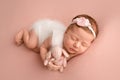 Newborn baby girl sleeping in a white jumpsuit with pink rabbit a white bandage Royalty Free Stock Photo