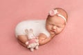 Newborn baby girl sleeping in a white overalls, with a white bandage on her head Royalty Free Stock Photo