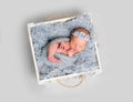 Newborn baby girl asleeps in wooden box