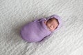 Newborn Baby Girl Swaddled and Wearing a Lavender Bonnet