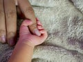 Newborn baby grasping her mothers finger. Concept of baby care, feeling safe, parent love. Selective soft focus Royalty Free Stock Photo