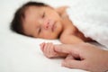 Newborn baby hand holding index finger of mother on bed Royalty Free Stock Photo